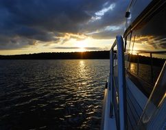 luxury ship on lake at sunset and dark clouds