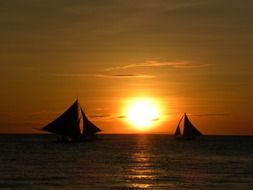 sailboats at bright sunset