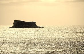 dark rock in the middle of the sea