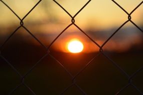 red sun behind bars