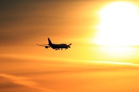 silhouette of the plane in the orange sky