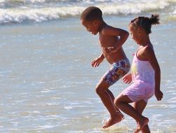 children playing on the beach in the water