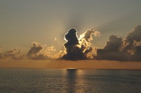landscape of evening sun behind a cloud above the lake