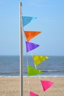 pennant with colorful flags on a sand beach