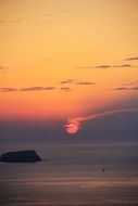 red romantic sun at sunset over Santorini island, Greece