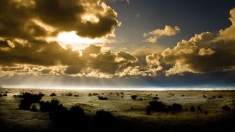 the sun behind the clouds over the sea in the evening