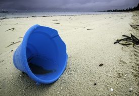 blue abandoned bucket on the beach