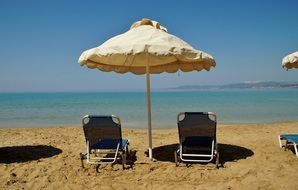 two loungers and a beach umbrella on the sand