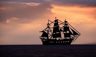 silhouette of a ship at sea during sunset