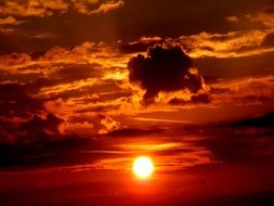 Bright sun at sunset amid the clouds