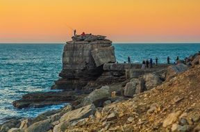 fishermen on a rock on the coast
