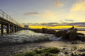 waves near the pier on the ocean at sunset