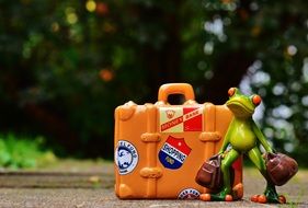 Toy frog with big suitcase