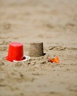sand figure near red bucket