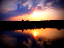 The setting sun is reflected in the lake