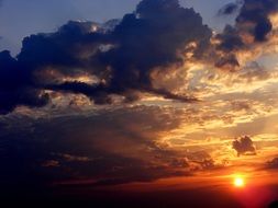 Huge clouds against the sun at sunset