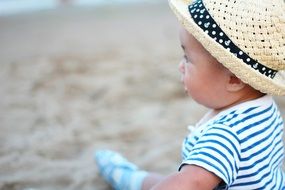 happy kid in the hat on the beach