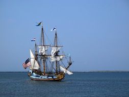 travel boat with white sails in the ocean