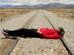 Woman is lying on the railway