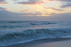 stormy ocean waves against the evening sky