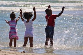 African children are splashing in the water on the ocean