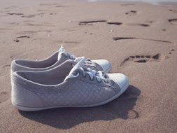 white sneakers on the sand beach