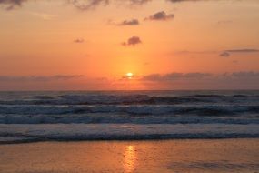 tropical beach in the rays of a bright sunset