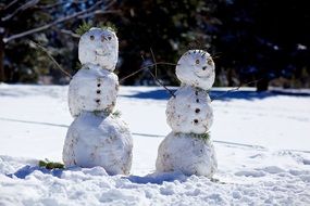 two snowman in the bright sun
