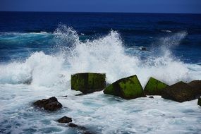 breakwater of ocean waves water sprays stone blocks