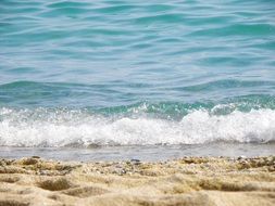 foamy sea waves aplashing on sand beach