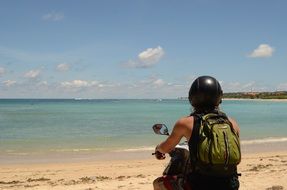 girl on a scooter on a beach in Bali
