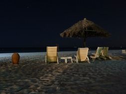 sun loungers on the beach in the dark