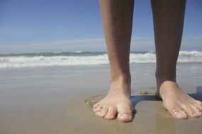 feet on wet sand close up