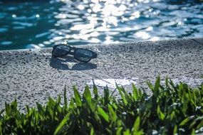 sunglasses on the side of the pool