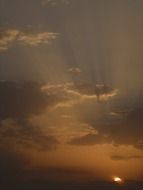 the sun's rays of the evening sun through the clouds