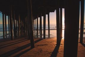 sand under the wooden pier