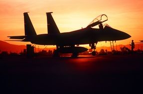 silhouette of military aircraft on a background of red sunset