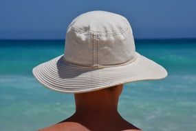 person in hat, sea, back view