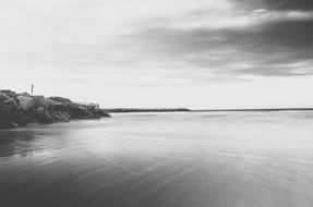 pier on rocky coast, black and white