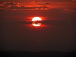 landscape of red sunset behind a cloud in the evening sky