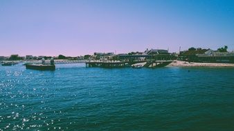 pier on blue water at sand coast