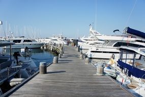 white yachts near a wooden pier