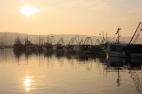 fishing boats in port during sunset