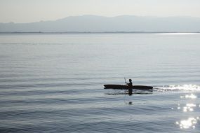 canoeing paddle on glittering surface lake