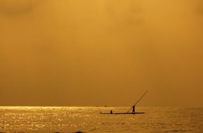 man on a raft against a yellow sunset