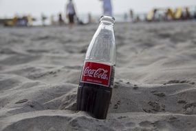 Coca-Cola bottle on the sand