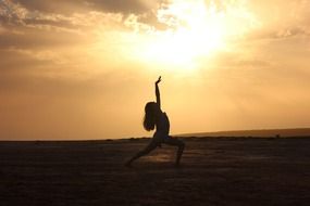 silhouette of a dancing girl on a sunset background