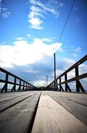 wooden bridge under blue sky, perspective