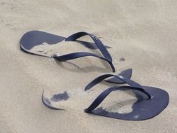 Blue flip-flops in sand