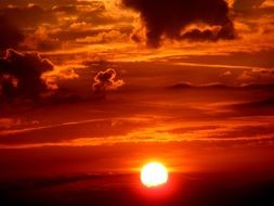 Clouds over the bright sun at sunset